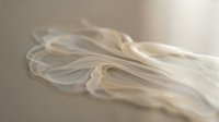 Flowing white silk fabric with elegant curves and soft folds creating graceful movement against neutral background for luxury fashion design projects.