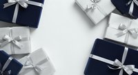 Wrapped gift boxes in navy and silver with white ribbons arranged on white background, suitable for holiday, celebration, and festive design projects.