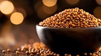 Brown mustard seeds in black ceramic bowl on dark background with golden bokeh lights, macro food photography highlighting natural texture and shine.