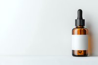 Amber glass dropper bottle with blank white label on white background, minimalist pharmaceutical mockup for essential oils and cosmetic products.