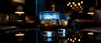 Whiskey glass with ice cubes on reflective surface in dark ambiance with warm bokeh lights, suitable for beverage and lifestyle advertising.