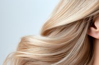Flowing blonde hair strands in motion against light background showcasing healthy, shiny texture and natural movement for beauty and haircare advertising.