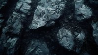 Dark rocky cliff face with rough textured surface and deep shadows creating dramatic natural pattern. Moody geological formation in monochromatic tones.