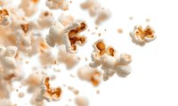 Exploding popcorn kernels captured in dynamic motion against white background, with golden butter highlights creating dramatic contrast and texture for food advertising.