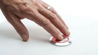 Male hand with fair skin pressing red emergency button on white surface for alarm, alert, or crisis response situations.