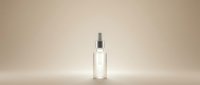 Clear glass dropper bottle with silver cap on neutral beige background for skincare serum cosmetic product packaging and beauty brand marketing.