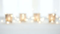 Soft blurred golden lights creating warm bokeh effect on white background for holiday decorations and festive atmosphere design projects.