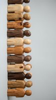 Wooden peg dolls in various natural tones arranged vertically, showcasing different wood types and finishes for craft projects, educational materials, and decorative displays.