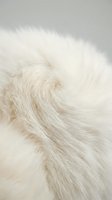 Soft white fur texture with natural swirl pattern creating luxurious cozy background for winter fashion and home decor projects.