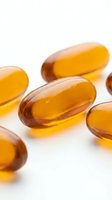 Golden amber gel capsules with glossy finish arranged on white surface for nutritional supplement, vitamin, and wellness product marketing.