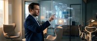 Professional businessman in dark suit interacting with futuristic holographic interface displaying data analytics and digital elements in modern office.