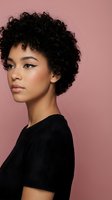 Young mixed-race woman with curly afro hair and winged eyeliner makeup posing against pink background wearing black top for beauty and fashion concepts.