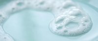 Clear bubbles floating in turquoise water creating ripples and reflections. Refreshing aqua surface with oxygen bubbles for spa and wellness concepts.