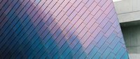Modern architectural facade with gradient color transition from blue to pink metallic panels arranged in diagonal linear pattern, suitable for contemporary design, corporate branding, and architectural visualization projects.