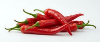 Fresh red chili peppers with green stems isolated on white background, ready for culinary, food, and cooking design projects.