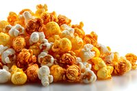 Colorful popcorn pile with yellow, orange, and white kernels on white background, perfect for movie night snack or party food photography.
