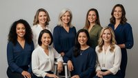 Diverse group of professional businesswomen in corporate attire posing together for team portrait in modern office setting for leadership concepts.
