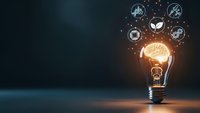 Glowing light bulb with brain inside surrounded by technology icons representing artificial intelligence innovation and creative thinking concepts.