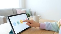 Customer feedback rating concept with hand selecting happy emoji on tablet screen for service evaluation and satisfaction survey in modern office workspace.