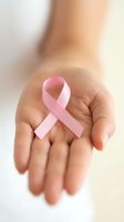 Hands holding pink ribbon symbol for breast cancer awareness campaign and women health support advocacy.