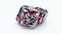 Iridescent metallic mineral rock with holographic rainbow reflections on white background, isolated for design use in science, jewelry, and luxury projects.