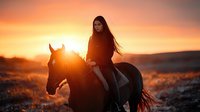 Young Asian woman riding horse at sunset, silhouetted against golden sky with long flowing hair and dramatic backlighting creating atmospheric outdoor scene.