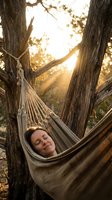 Peaceful woman relaxing in hammock between trees during golden hour sunset, enjoying tranquil outdoor moment for wellness and mindfulness retreat concepts.