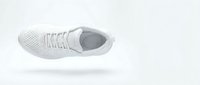 White athletic sneaker with knit upper floating on light background, top view. Minimalist sport shoe isolated for fashion and footwear design.