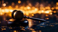 Wooden gavel on dark surface with warm golden bokeh lights background for legal justice court law attorney judge concepts.
