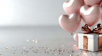 Pink heart-shaped balloons with gift box and golden confetti on white background for Valentine's Day celebration and romantic occasions.