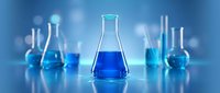 Laboratory glassware with blue chemical solutions on reflective surface for scientific research and experimentation in modern chemistry lab setting.