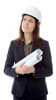 Female architect or engineer with long brown hair and Caucasian ethnicity wearing white safety helmet and dark blazer holding rolled blueprints, looking upward thoughtfully on white background for construction and professional design projects.