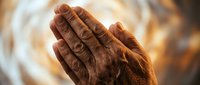 Elderly hands pressed together in prayer position with warm golden light creating spiritual atmosphere for meditation and faith concepts.
