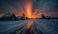 Dramatic winter sunset over snowy rural village with wooden houses and dirt road reflecting golden orange light rays through cloudy sky creating magical atmosphere.