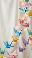 Colorful origami paper cranes hanging mobile decoration with soft bokeh lights background for nursery room interior design and craft projects.