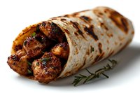 Grilled chicken kebab wrapped in fresh flatbread with herbs and spices, served on white background. Close up view of middle eastern street food cuisine.
