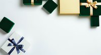 Wrapped gift boxes in forest green and cream with gold and navy blue ribbons arranged on white background, isolated for holiday design projects.
