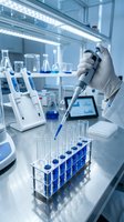 Scientist hand in glove using pipette with blue liquid samples in modern laboratory for medical research and chemical analysis experiments.