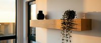 Wooden floating shelf with black vase and cascading pothos plant against white wall, modern home decor and interior design styling for residential spaces.