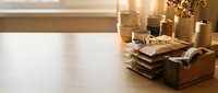 Wooden desk with stacked books, candles, and gold decorative items creating a warm, organized workspace for home office, study, or interior design projects.
