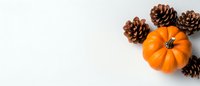 Autumn composition with small orange pumpkin and pine cones on white background, perfect for seasonal holiday designs.