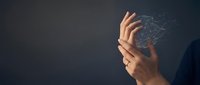Digital network connections emanating from human hands against dark background representing technology, connectivity and data transfer concepts.