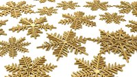 Golden metallic snowflakes scattered on white background for holiday decorations, Christmas crafts, winter celebrations and festive design projects.