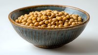 Fresh soybeans in rustic ceramic bowl with blue glaze against light background, raw organic legumes for healthy protein-rich cooking and Asian cuisine.