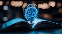 Glowing blue brain-shaped light bulb floating over open book with bokeh background creates magical atmosphere of knowledge and innovation.