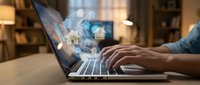 Businessman using laptop with holographic real estate icons and house symbols for property investment and digital marketing applications.