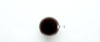 White coffee cup with black coffee viewed from above on clean white background for morning beverage and cafe design projects.