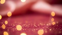 Elegant burgundy red background with golden bokeh lights and sparkling glitter effects creating luxurious festive atmosphere for holiday celebrations.