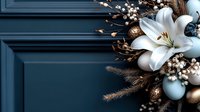 White lily and golden ornaments on dark teal background with copy space. Elegant Christmas or winter holiday floral arrangement featuring white flowers and blue baubles.
