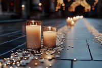 Romantic candles glowing on wooden deck with scattered petals and warm bokeh lights creating intimate evening atmosphere for wedding or special occasion.